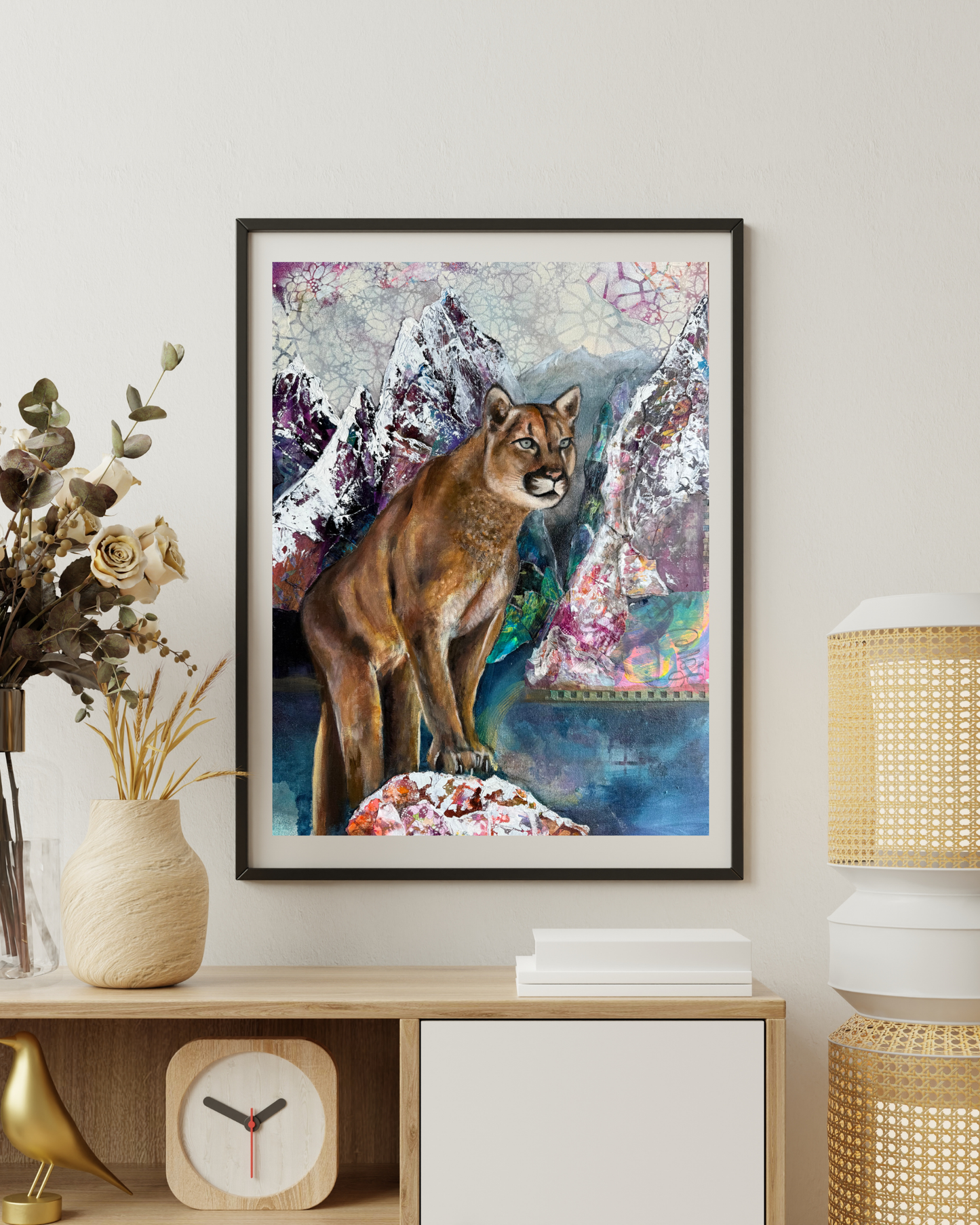 Canvas painting of a mountain lion on a wall above a wooden shelf with decorative items.